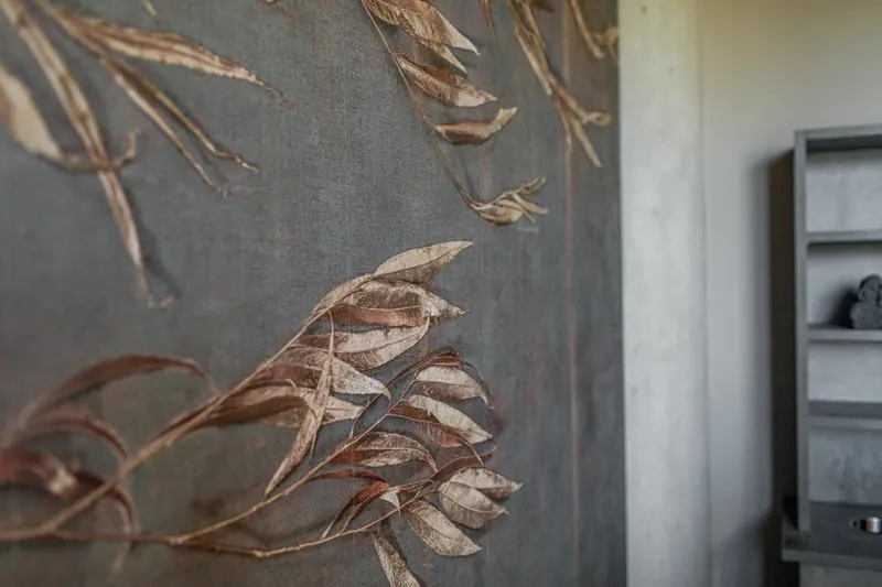 Detail einer dekorativen Wandgestaltung mit goldenen Blättern
