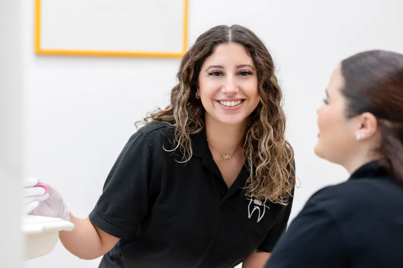 Mitarbeiterin einer Praxis im Gespräch mit einer Patientin